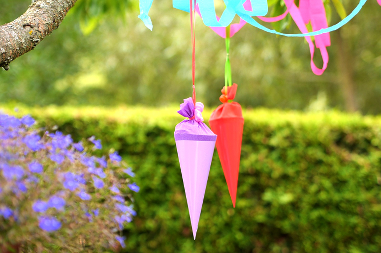 Bunte Papptüten als Sommerfest-Dekoration im Garten der Kita