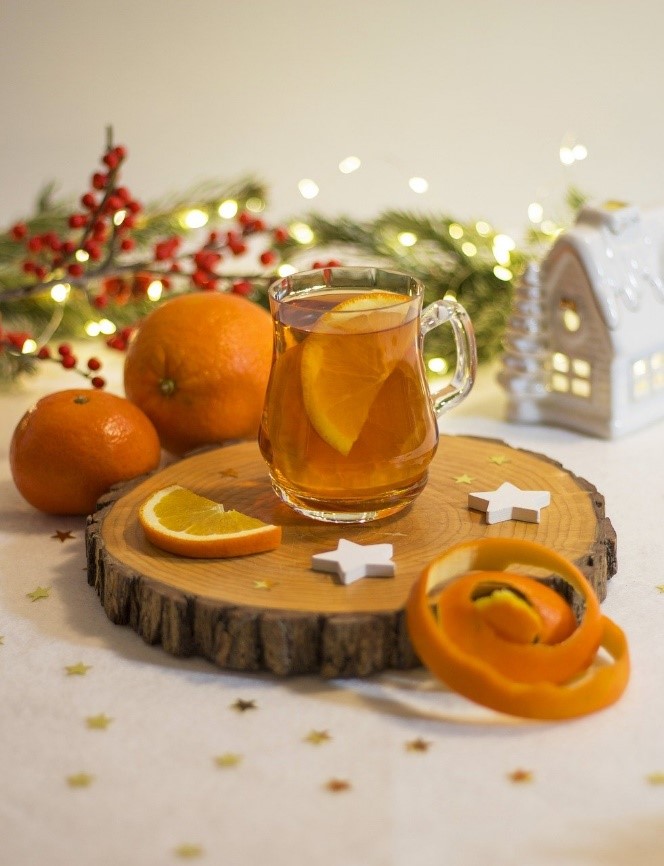 Weihnachtlicher Früchtetee mit Orange und festlicher Dekoration