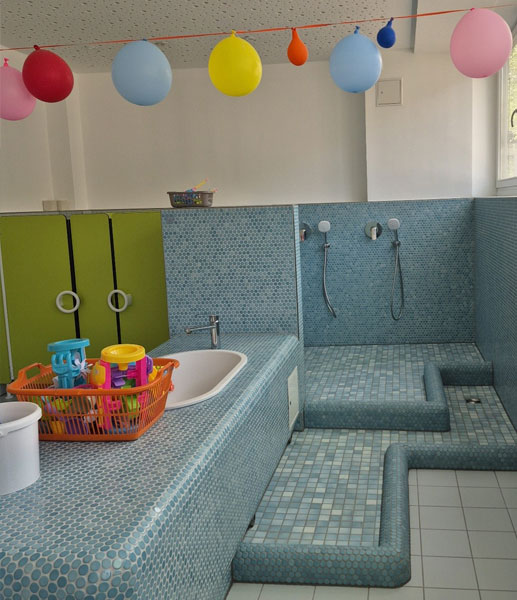 Wasserspielraum der Kita mit Wasserspielzeug und Duschbereich