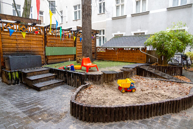 Hof der Kita Reuterstraße mit Sandkasten und Spielbereich